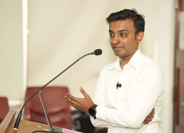 Vairavan speaking at a lectern during the GOPIO presentation